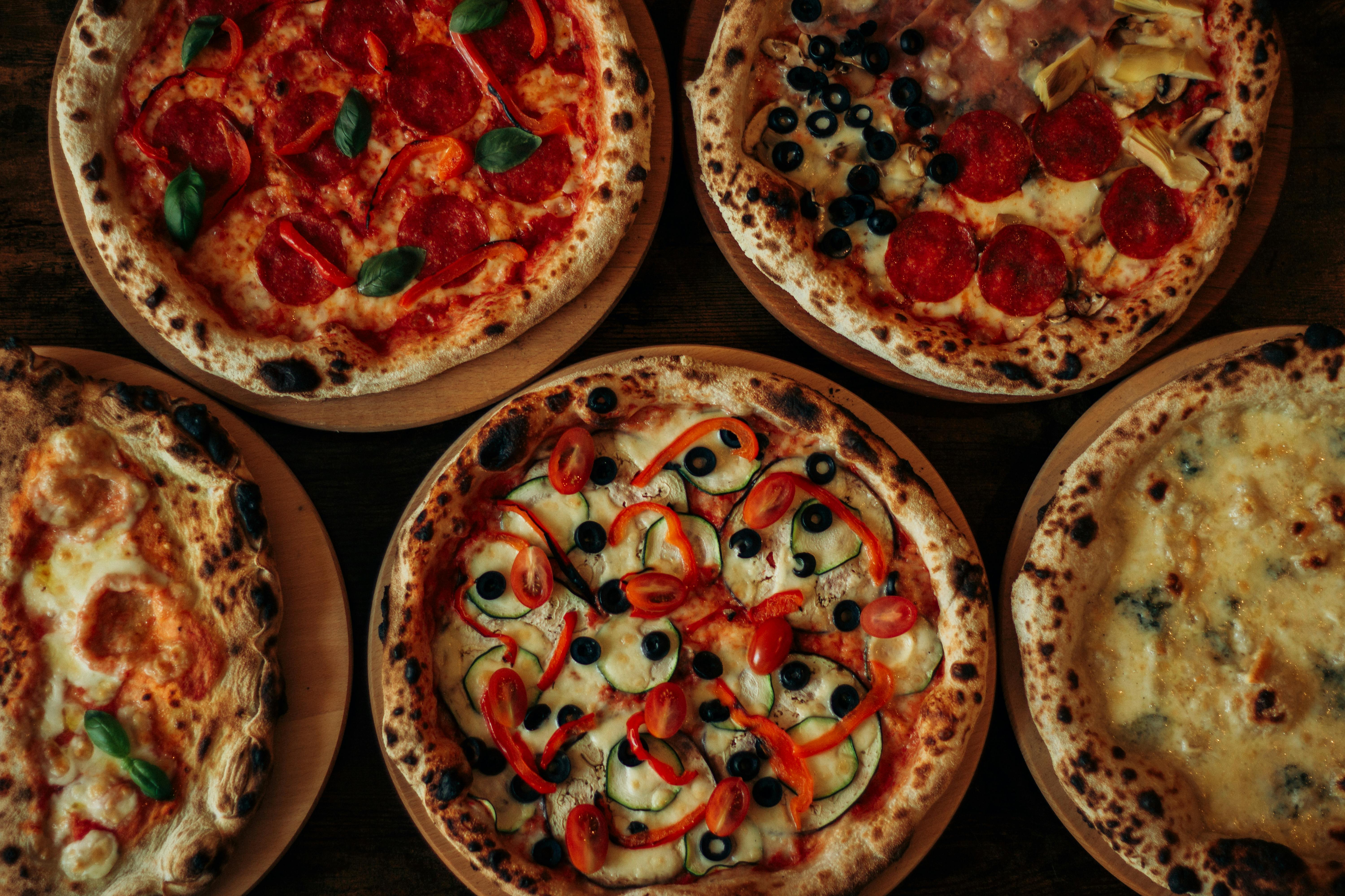 Wood-fired pizza coming out of the oven